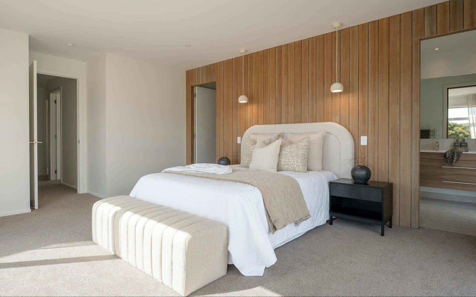 Main bedroom with timber feature wall and ensuite beyond in a Signature Homes build