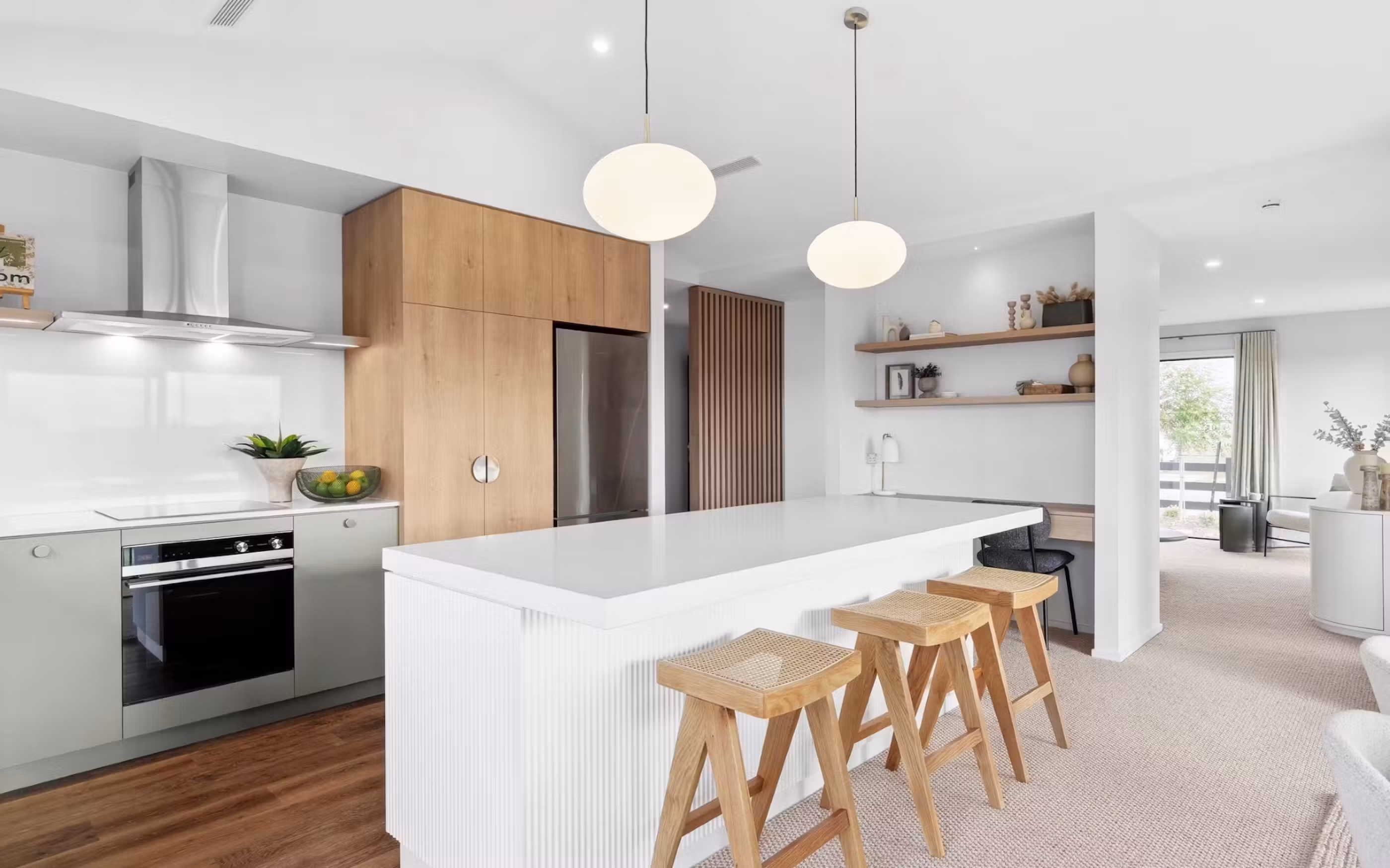 A bright, contemporary kitchen featuring warm timber finishes, a generous island and seamless open-plan living