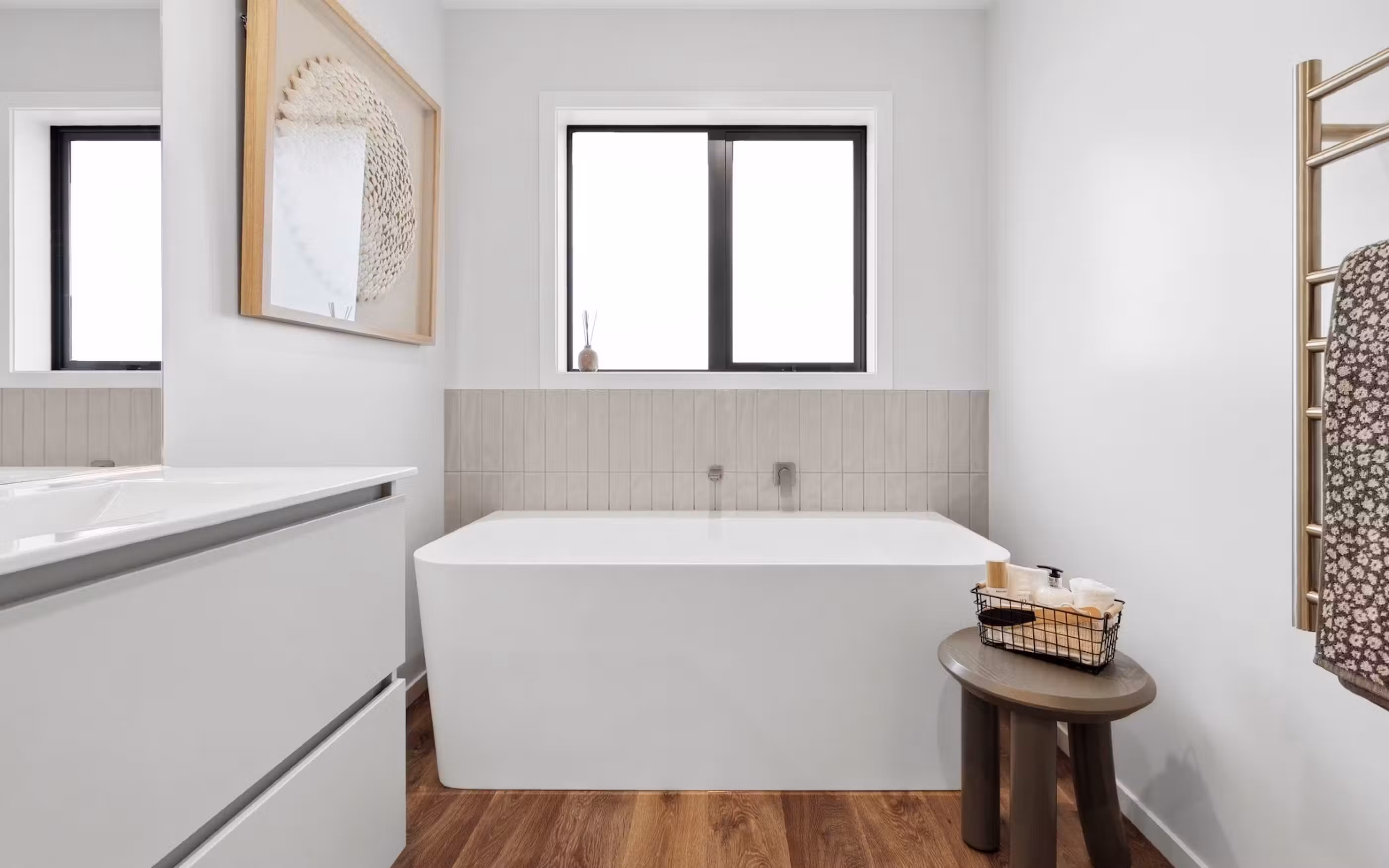 A contemporary bathroom featuring clean lines, warm timber tones and a generous freestanding bath.