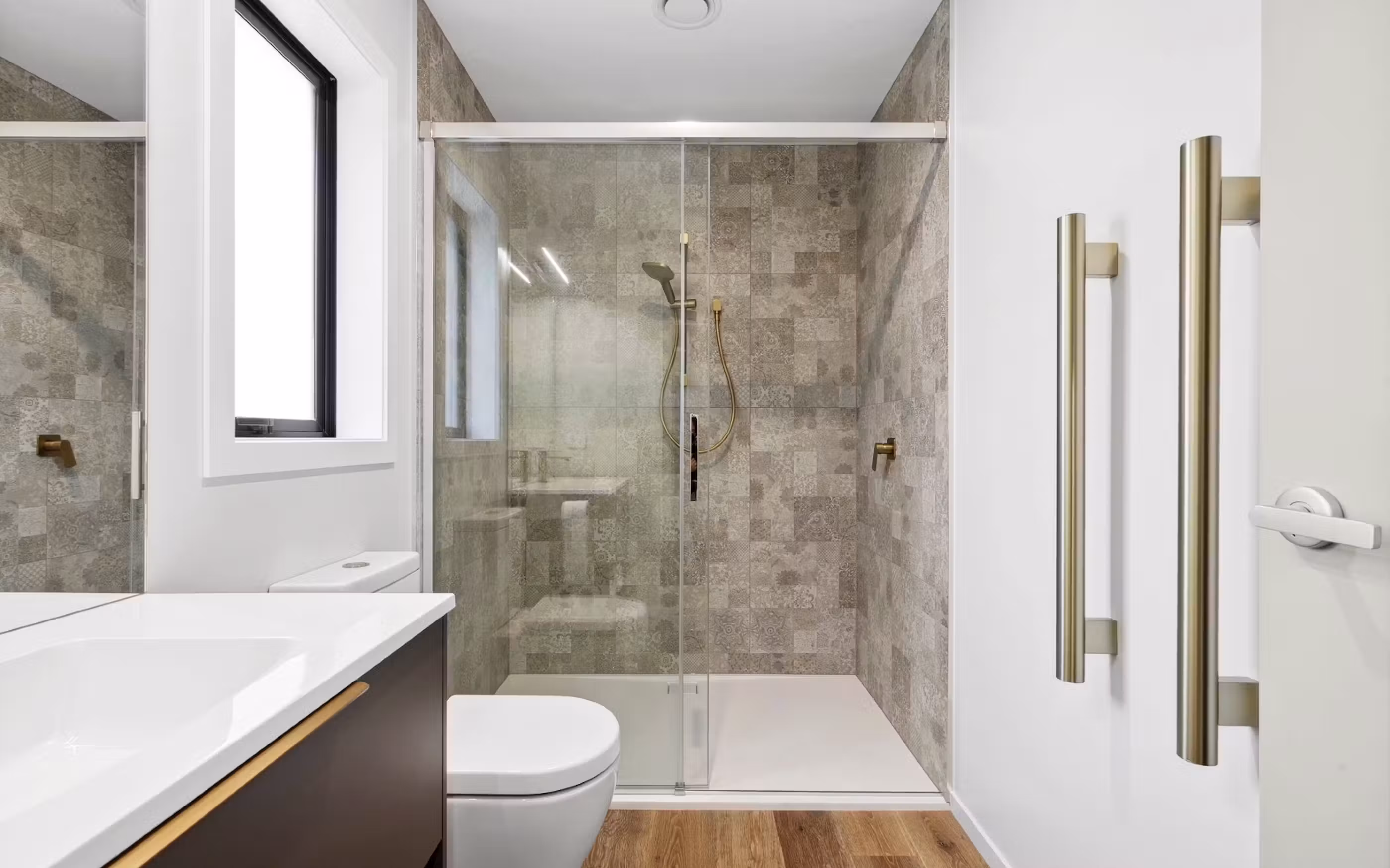A contemporary bathroom featuring a spacious tiled shower, warm timber tones and refined modern finishes.
